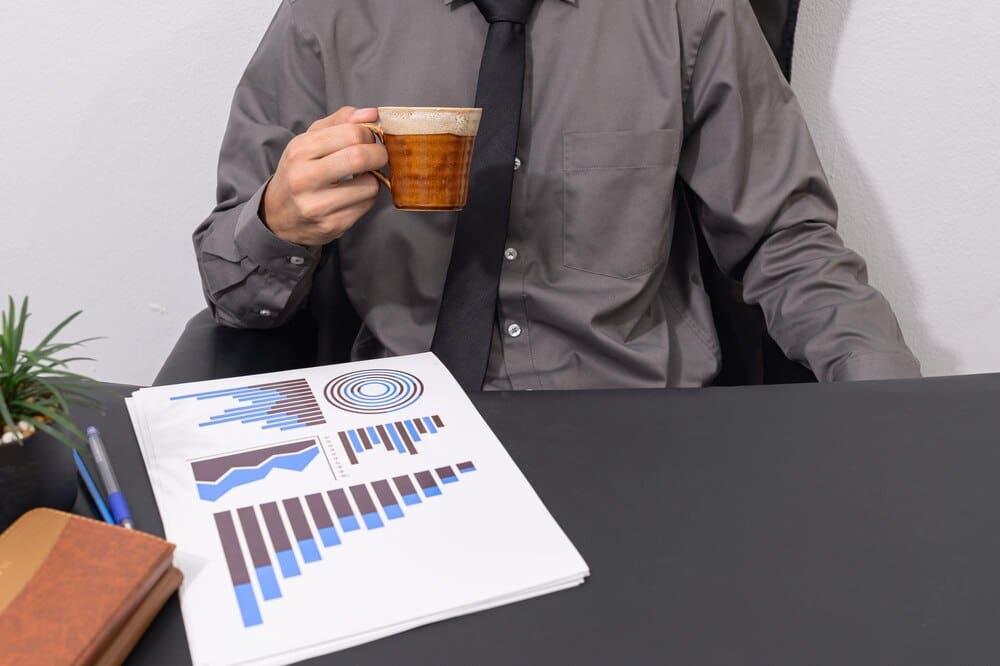 Midsection of a man holding a drink at a table.