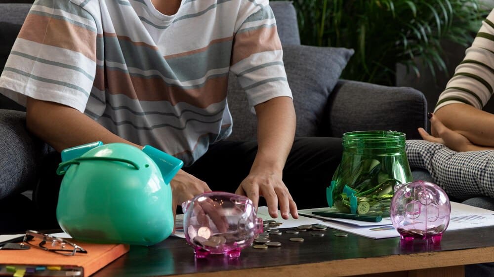 Man's midsection holding a drink while seated at a table.