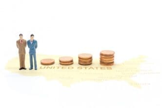 A tiny businessman stands on a map of the United States.