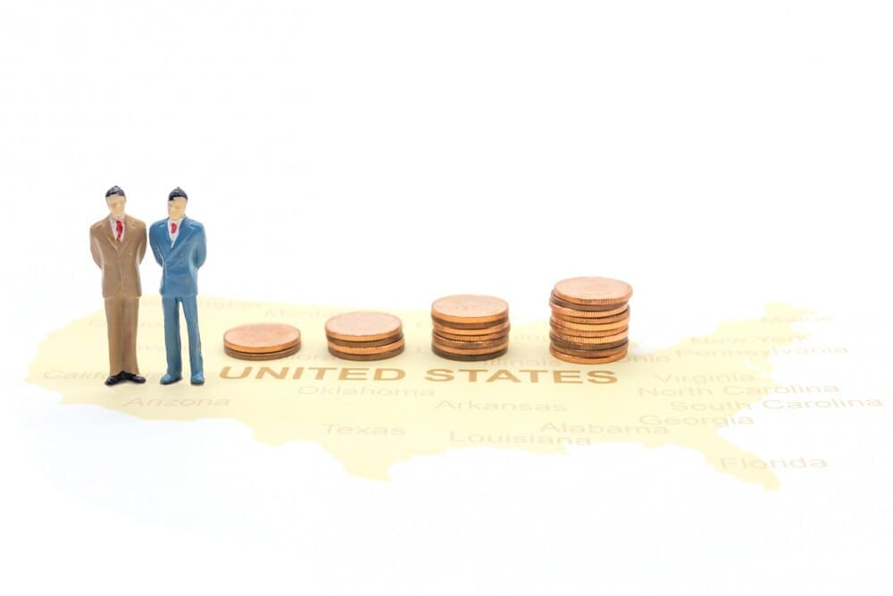 A tiny businessman stands on a map of the United States.
