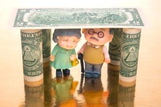 Miniature figures representing elderly people stand under a house-shaped structure labeled "dollars" to symbolize financial security and pension for the elderly.