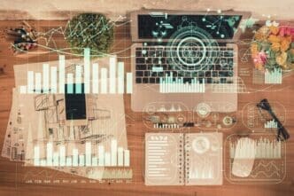 Overhead view of a table with a laptop, a pen, and a financial chart overlaid on the background.