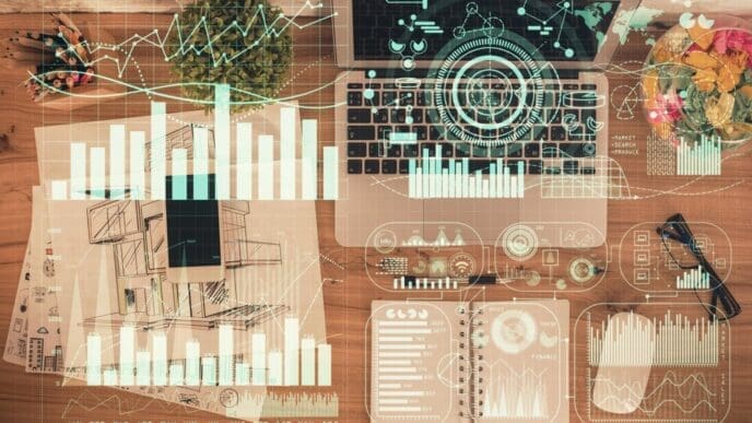 Overhead view of a table with a laptop, a pen, and a financial chart overlaid on the background.