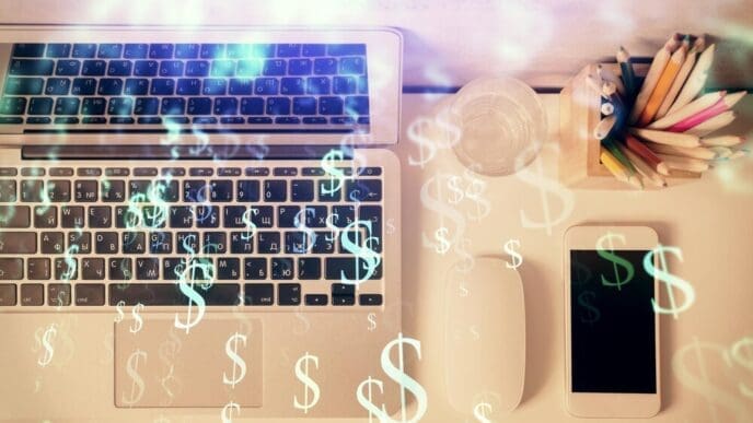Overhead view of a desktop with a computer and a multi-exposure image of a forex graph overlayed.