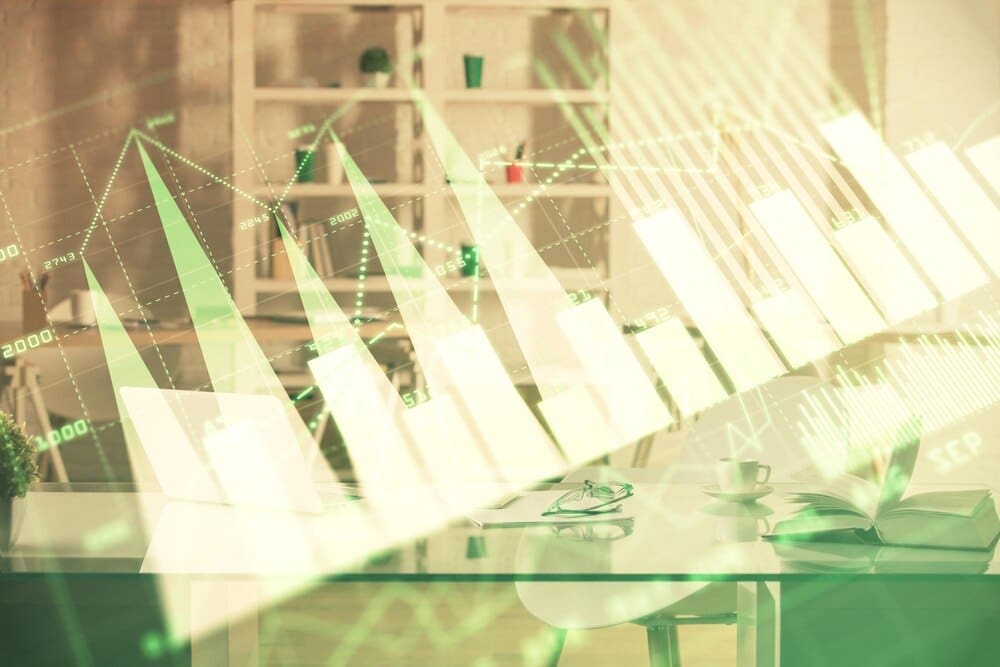 A multi-exposure image shows a stock market chart overlaid on an office interior, illustrating financial analysis concepts.
