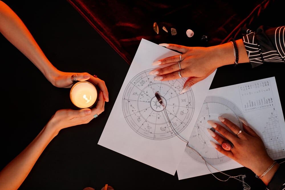 A person reads a numerology chart during a seance, likely for fortune-telling.