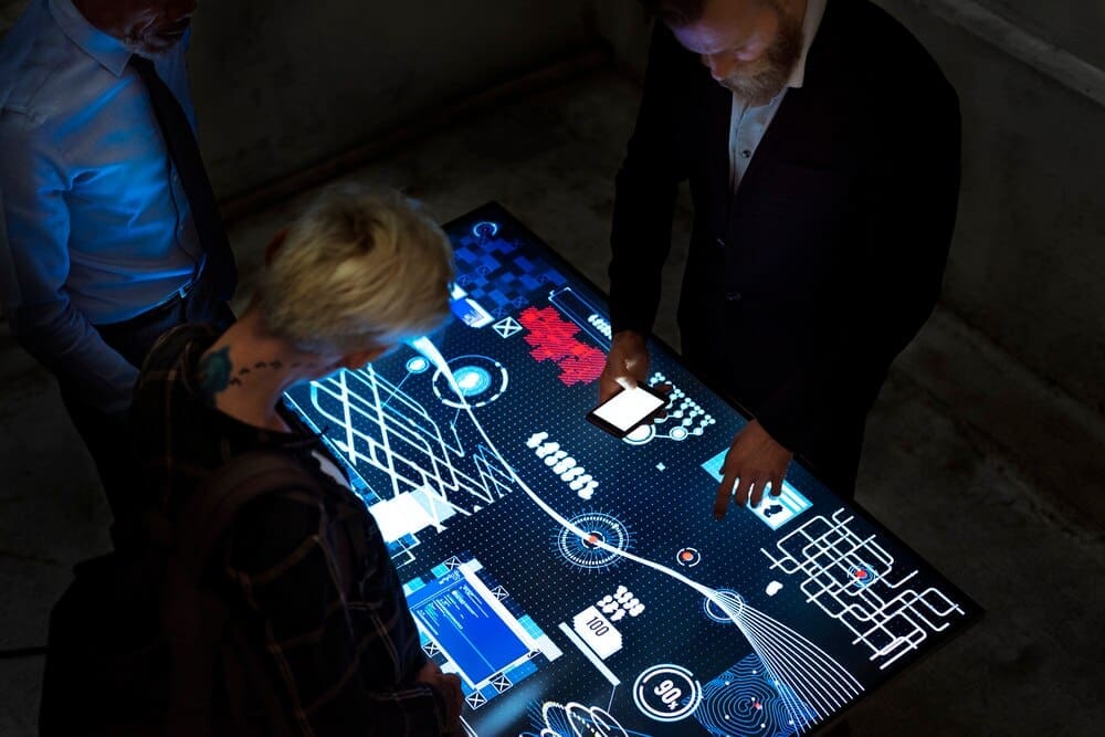 People wearing headsets and looking at screens in a futuristic, digital environment.