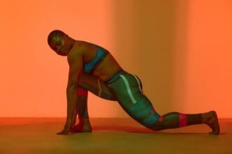 Full-length vertical portrait of a young Black woman in a sports top, showcasing a body-positive image.
