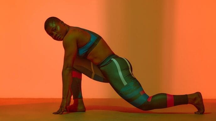 Full-length vertical portrait of a young Black woman in a sports top, showcasing a body-positive image.
