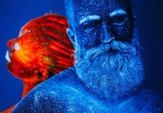 A colorful ultraviolet portrait depicts a bearded man and a woman.