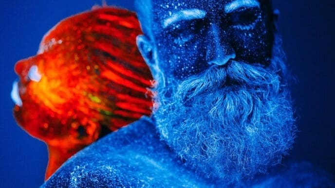 A colorful ultraviolet portrait depicts a bearded man and a woman.