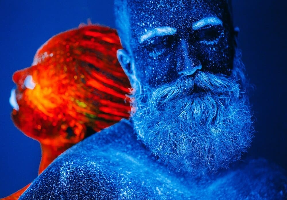 A colorful ultraviolet portrait depicts a bearded man and a woman.