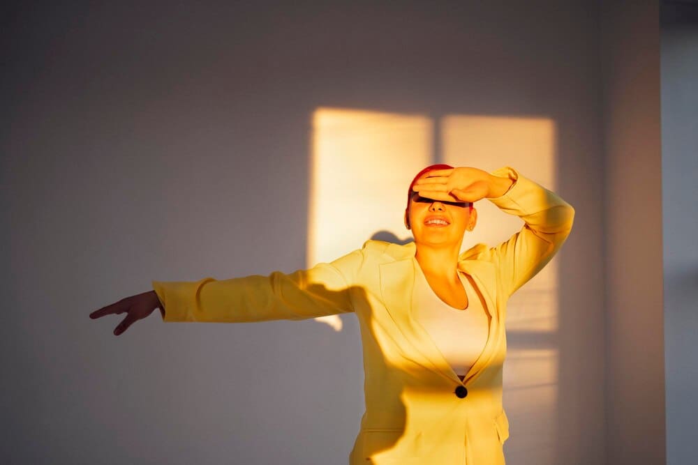 A young woman stands in front of a wall, likely posing for a portrait.