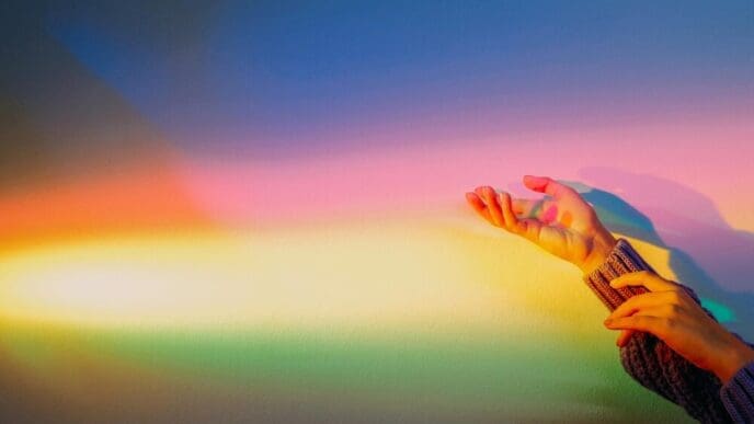 A woman's arms reach toward colorful, glowing light beams, suggesting hope and inspiration.