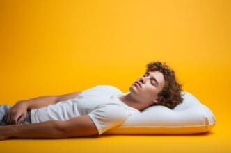 A young man reclines on a colorful inflatable mattress, appearing relaxed against a vibrant background.