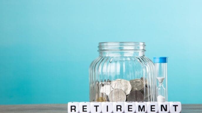 A person is putting coins into a piggy bank, symbolizing saving money for retirement.