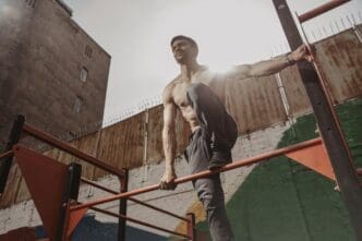 A shirtless athlete with a smartwatch works out outdoors, demonstrating calisthenics.