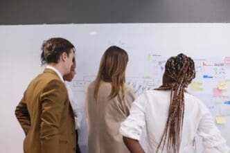 A diverse group of businesspeople are seated around a table, engaged in a meeting.