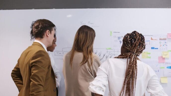 A diverse group of businesspeople are seated around a table, engaged in a meeting.