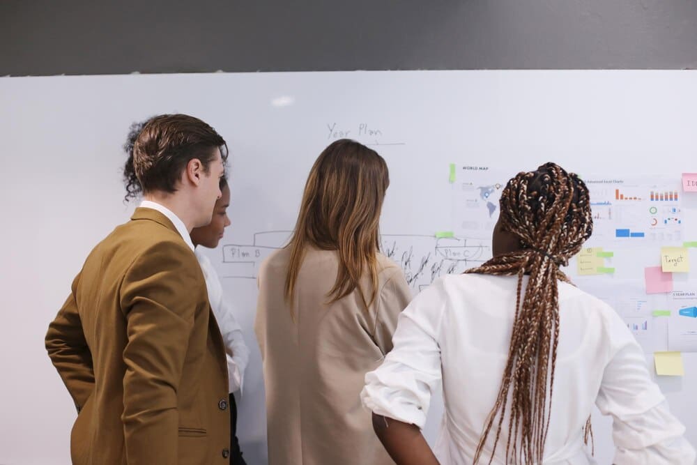 A diverse group of businesspeople are seated around a table, engaged in a meeting.