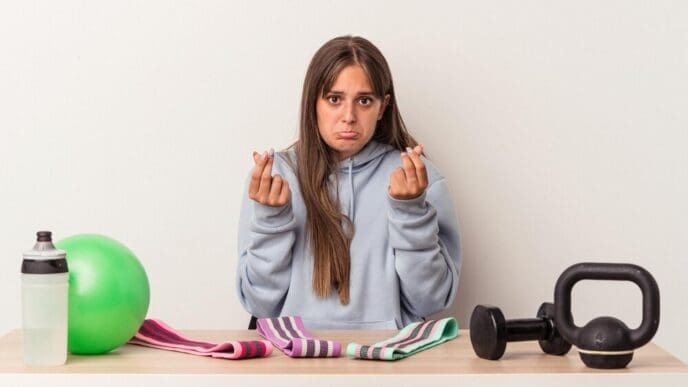 A person holds up empty pockets, demonstrating a lack of money.