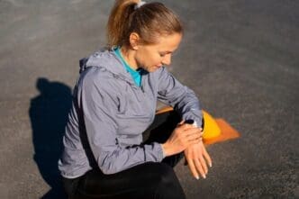 A woman in athletic wear trains outdoors, viewed from the side.