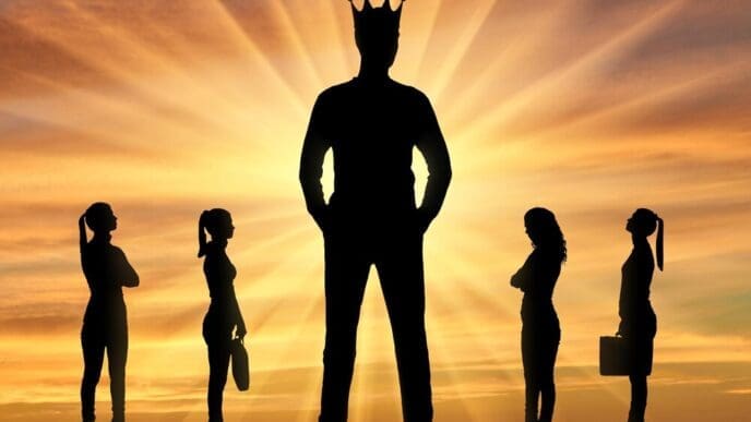 Silhouette of a large man wearing a crown stands prominently, with four smaller women positioned near him, representing gender inequality.