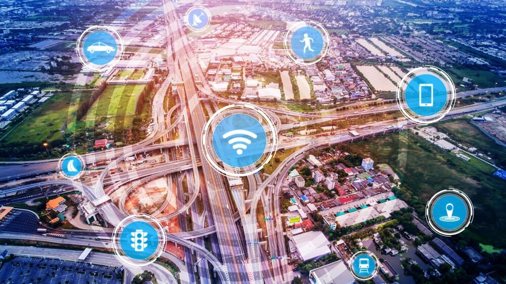 Illustration of a futuristic car driving on a road with digital overlays representing smart transport technology.