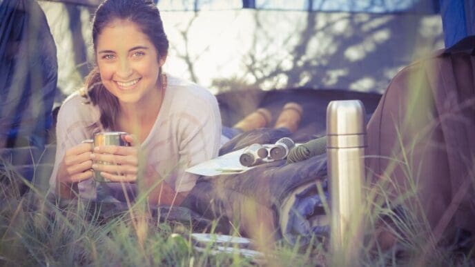 Smiling woman with brown hair reclines inside a tent.
