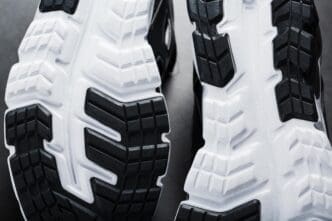 Close-up of the black and white sole of a running sneaker, showcasing sports technology.