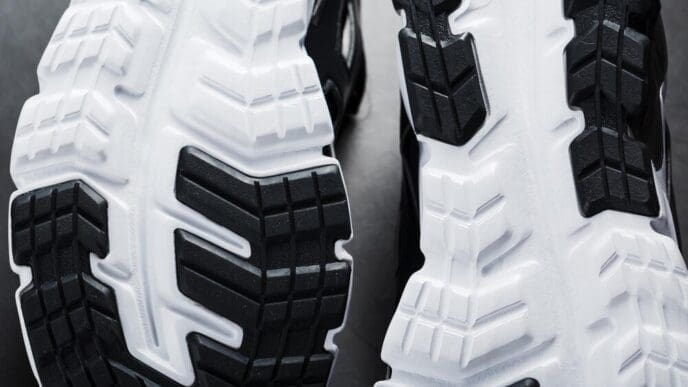 Close-up of the black and white sole of a running sneaker, showcasing sports technology.
