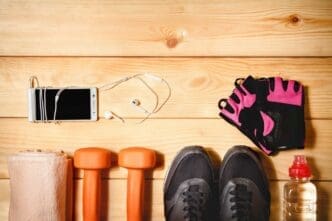 Sports equipment, including balls and cones, is arranged on a wooden floor.