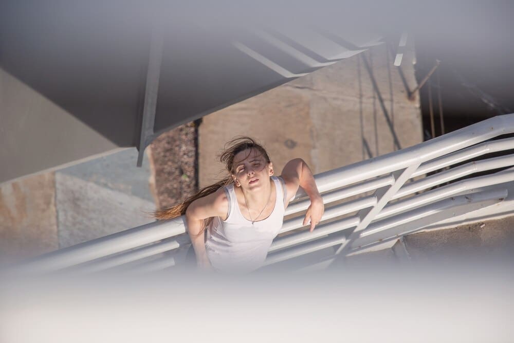 A sportswoman poses, looking upward.