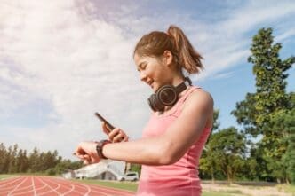 An Asian woman in athletic wear runs outdoors.