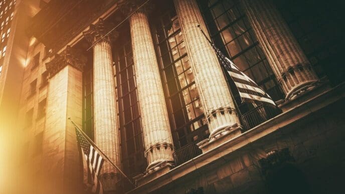 The New York Stock Exchange building features the American flag waving in front of its neoclassical facade.