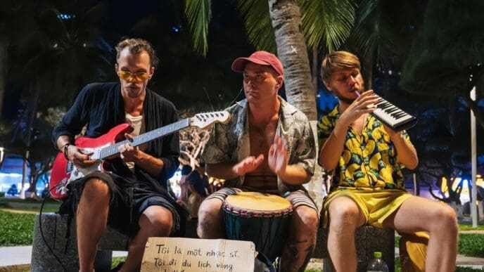 Street musicians prepare to perform in an alley in a park in Nha Trang, Vietnam, at dusk.