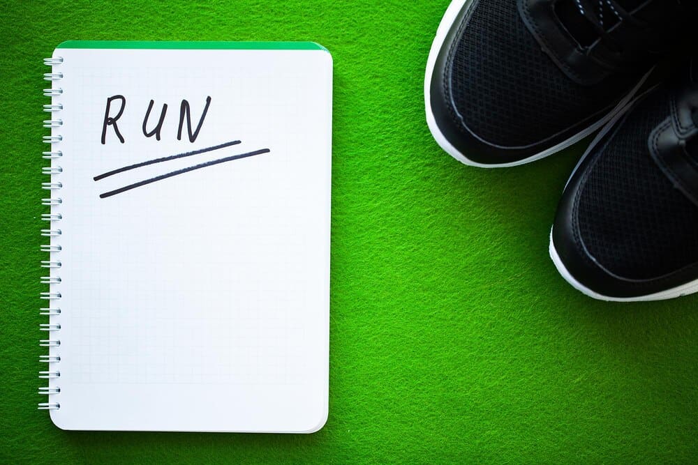 Black sneakers with a modern design against a vibrant green backdrop.