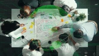 Top-down view of a team collaborating around a table, likely brainstorming ideas related to environmental sustainability.