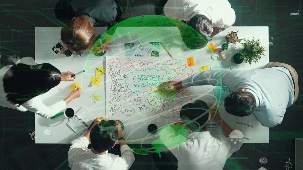 Top-down view of a team collaborating around a table, likely brainstorming ideas related to environmental sustainability.