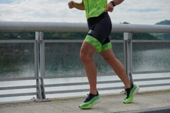 A triathlete runs on a paved street.