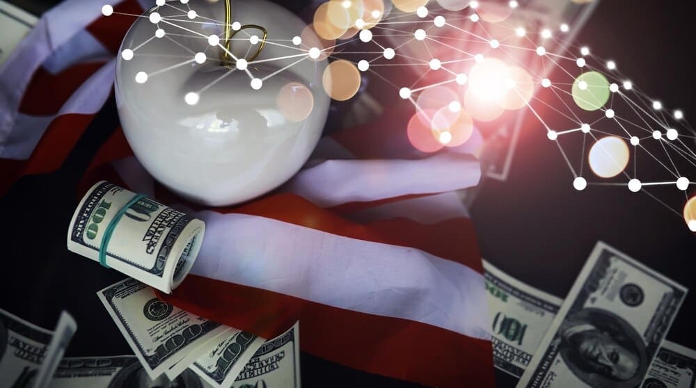 A red apple sits on a table covered with US dollar banknotes, representing business in New York City.