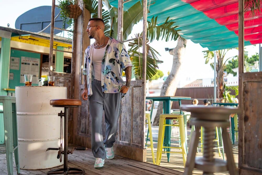 A white man with light hair poses for a photo shoot in a cafe.