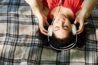 A woman is smiling while listening to music.