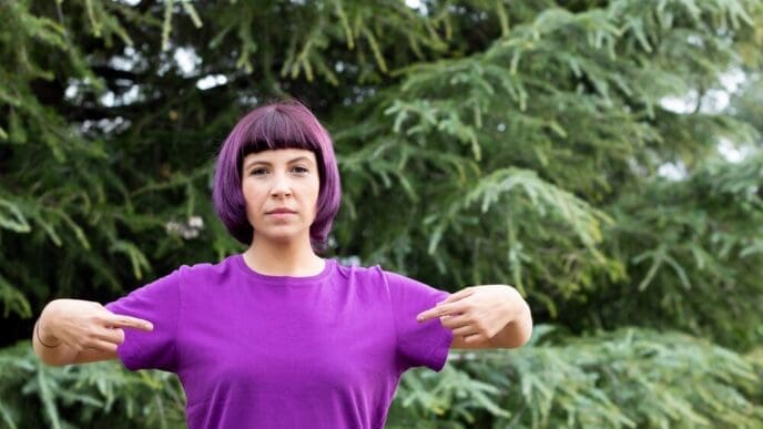A woman with purple hair is wearing a t-shirt.