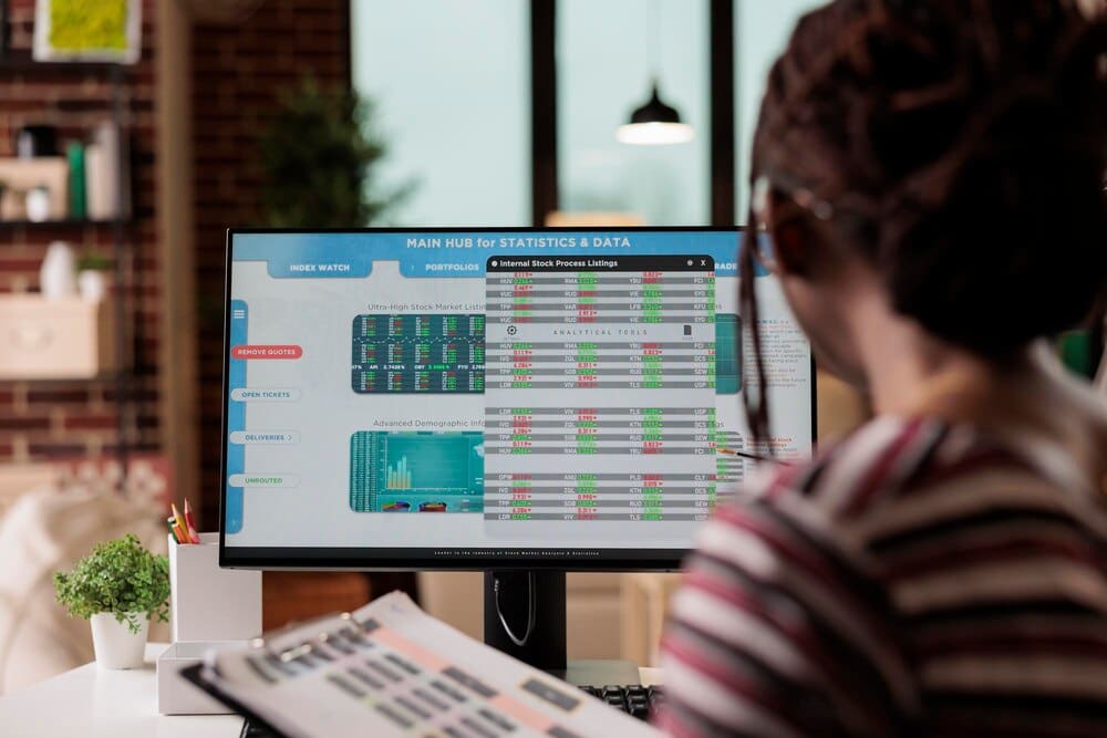 A woman analyzes data on a computer screen, likely related to the Internet of Things, as part of her work.