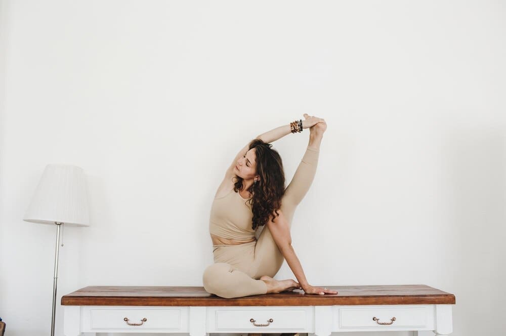 A young girl demonstrates flexibility while doing yoga and gymnastics.