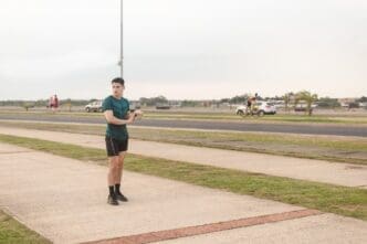 A young man stretches before starting a jog on a waterfront path.