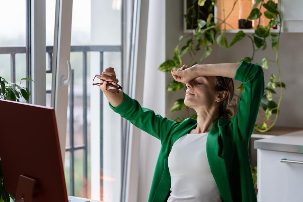 A young woman rests in a cozy room, appearing relaxed after working on a future business project.