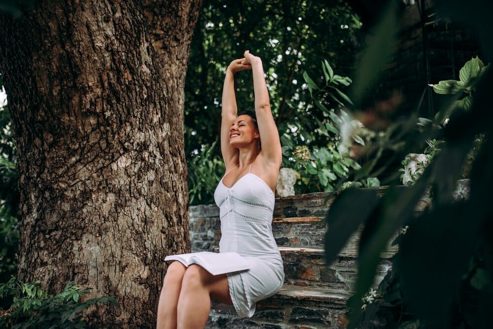A young woman relaxes in a park or garden.