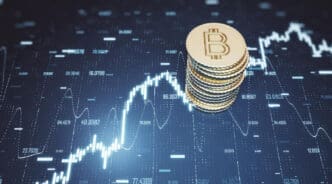 A stack of gold bitcoin coins on a background of a dynamic, glowing stock chart